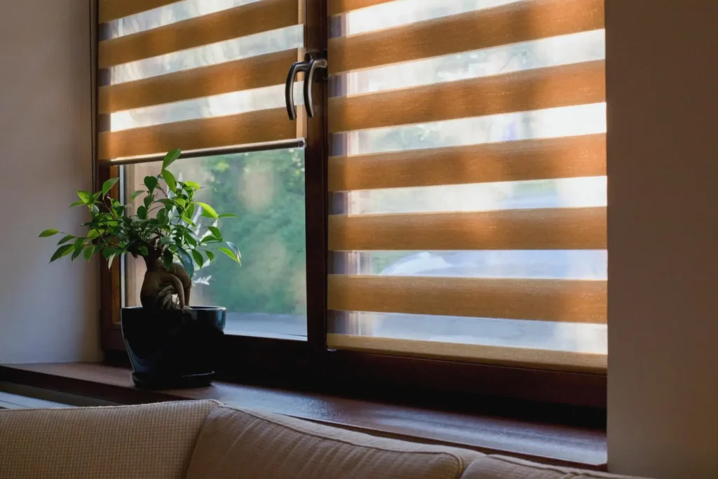 AdobeStock_267900558 Cozy zebra blinds covering a living room's windows.