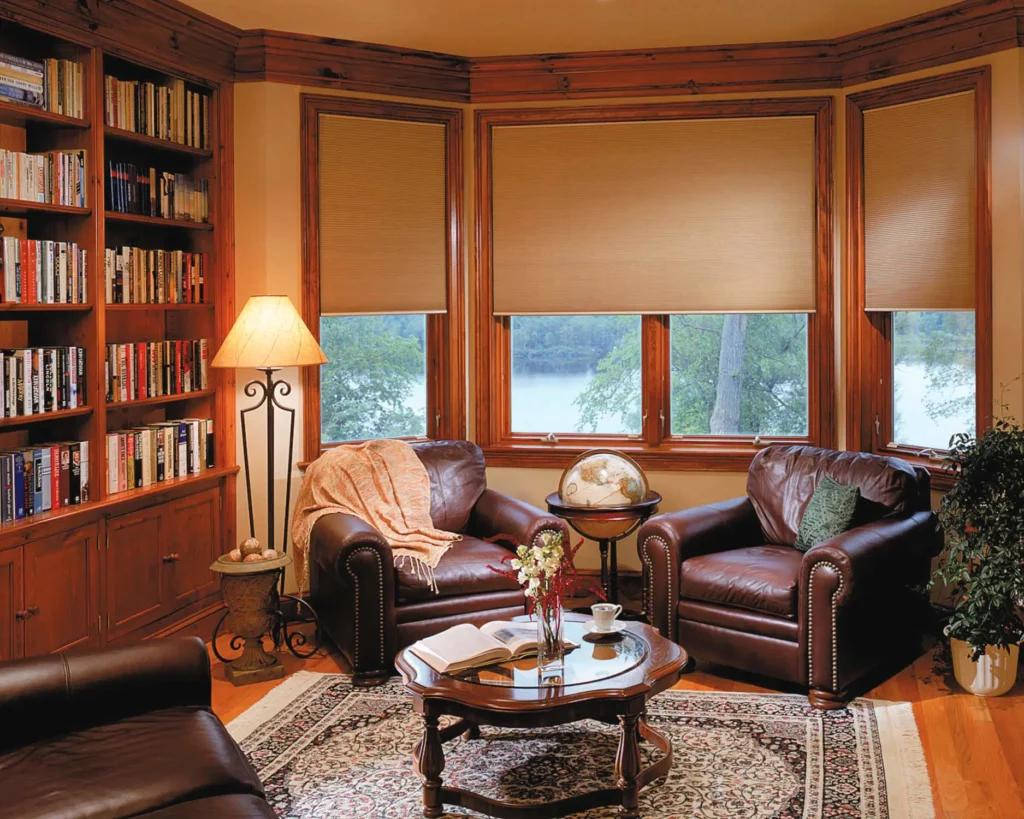 Honeycomb_055-opti Honeycomb window blinds covering the windows of a cozy study with a library.