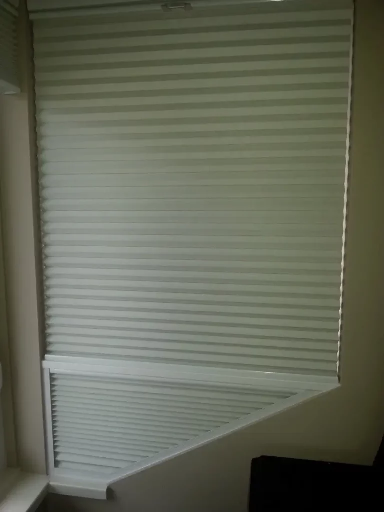 Custom honeycomb blinds, tailored made to a staircase window with a diagonal design