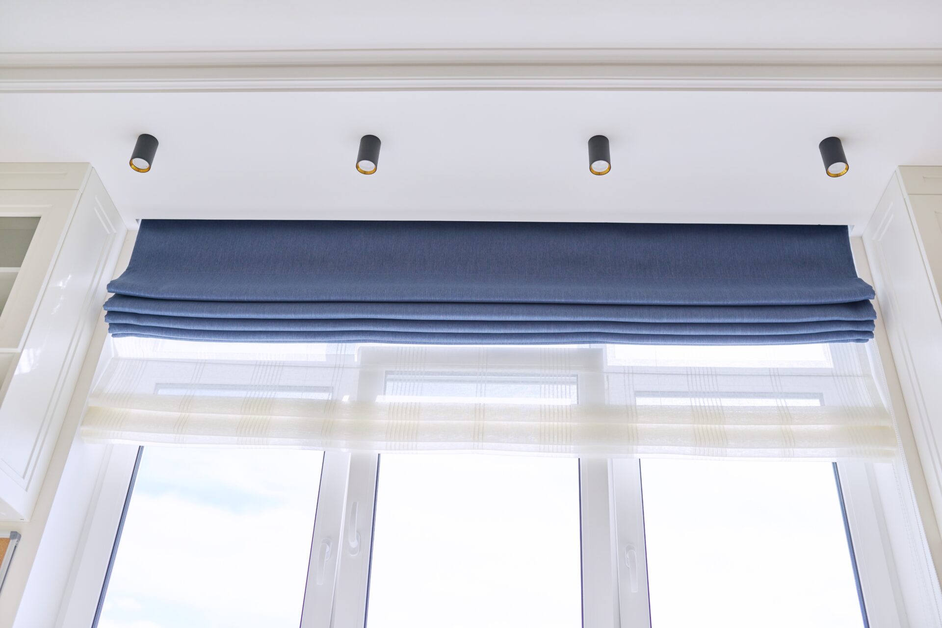 Blue roman blinds in the interior of a room. Blackout blinds to keep light out. Wholesale Blind Factory