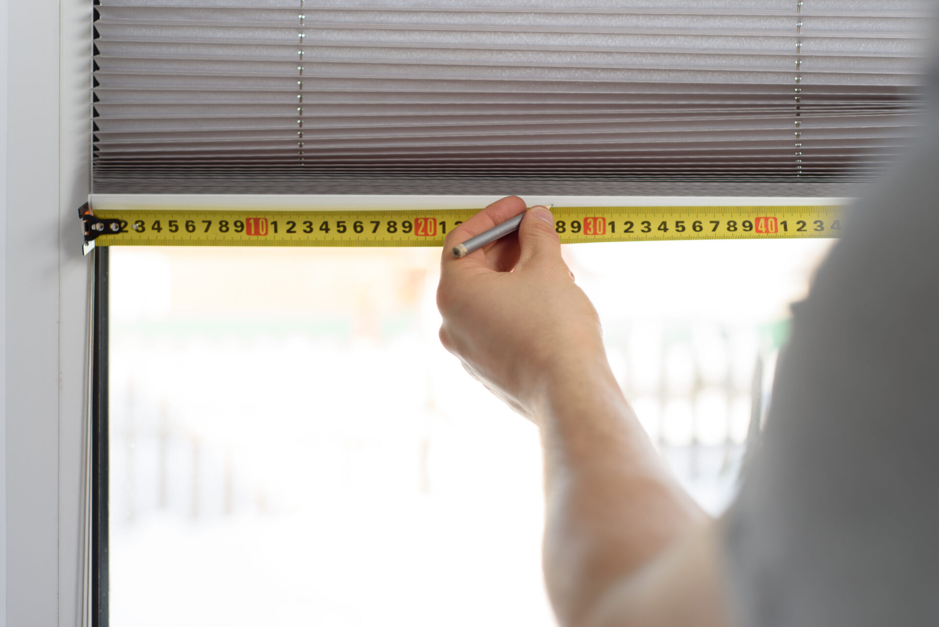 Man measuring window to install perfect fit blinds. Wholesale Blind Factory. 