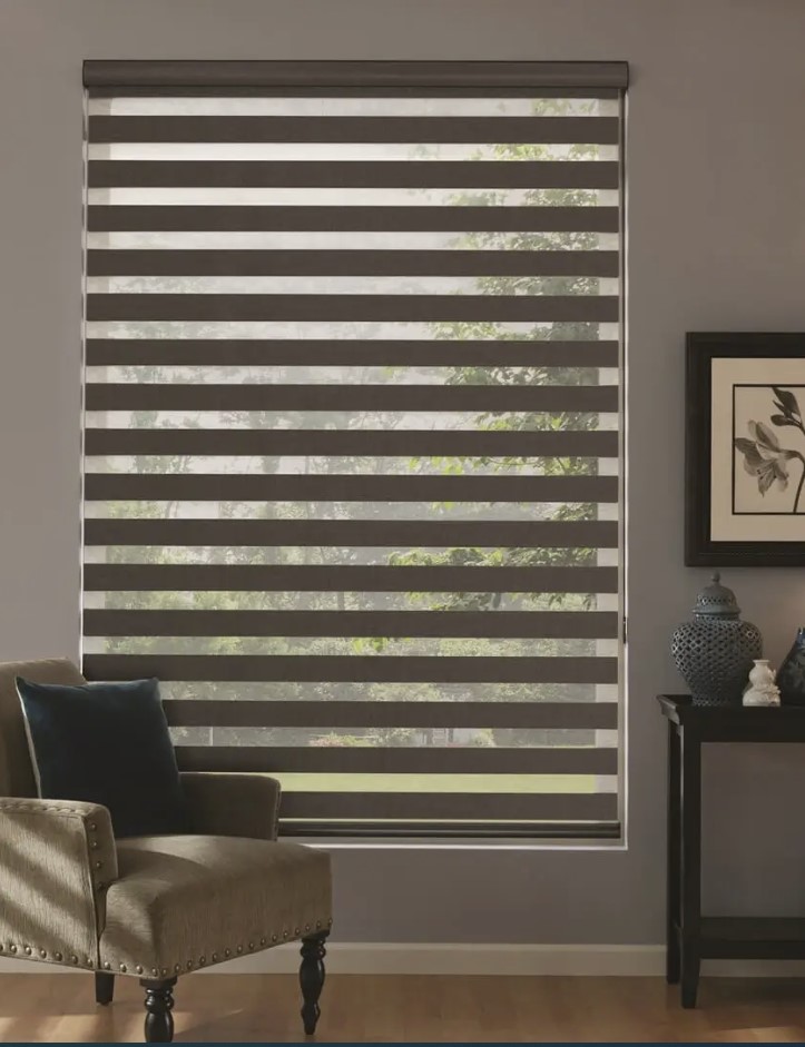 SHADES, REVOLVE SHADES 2 Zebra blinds covering a large vertical window of a studio.