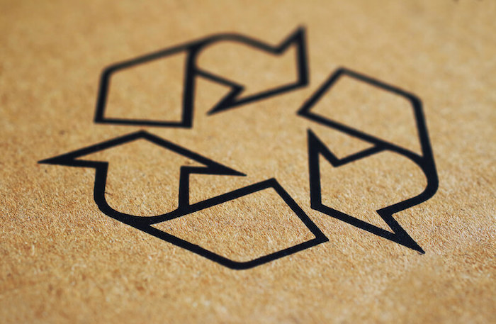 recycling symbol on cardboard texture